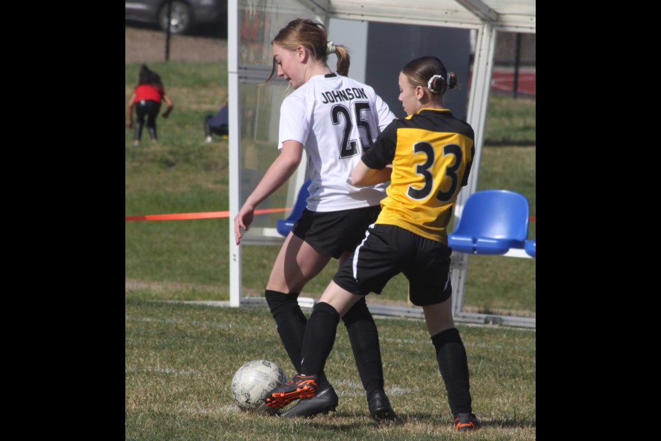 Hattie Johnson of the Bonnyville U13 girls’ team (white jersey) tussles with April Kuraitis of the Lac La Biche FC (yellow) during a match between the two Lakeland squads on the morning of May 10 held as part of Soccer Fest 2025. The fourth annual Soccer Fest event, which was hosted by Lac La Biche FC, featured young soccer players from across the Lakeland region. Chris McGarry photo. 
