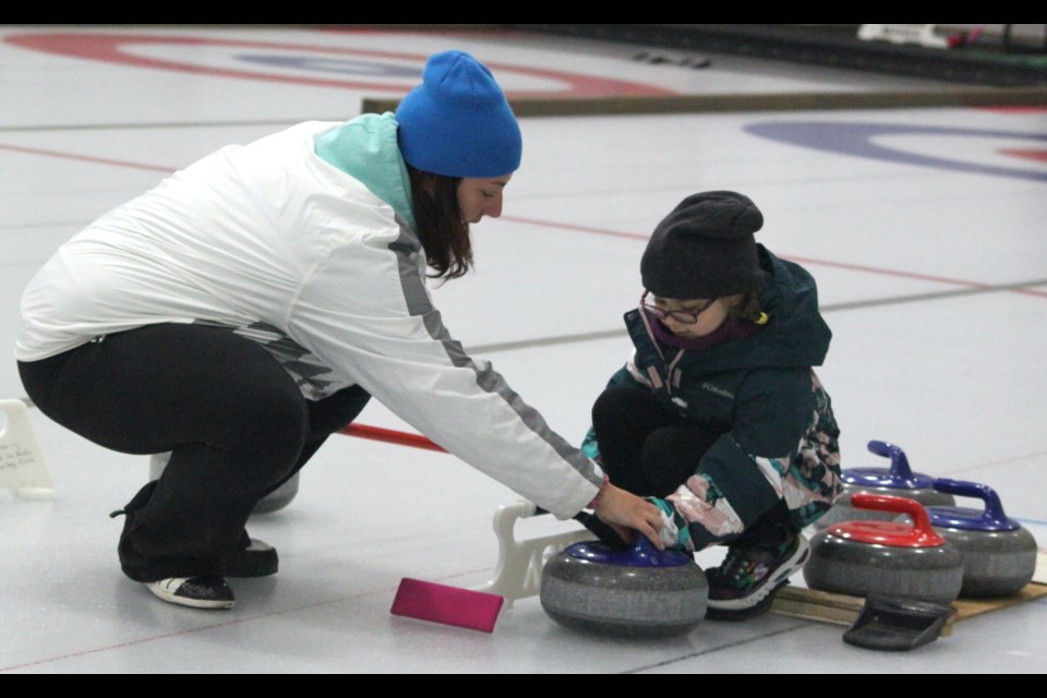 Ashley Twigge, an instructor for the junior curling group, gives Norah Thera some pointers during Tuesday’s practice at the Bold Centre. Chris McGarry photo. 
