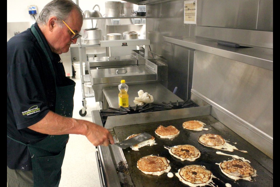Aurel Langevin, president of the Lac La Biche Agricultural Society, was busy Saturday morning in the kitchen of the Lac La Biche Agricultural Society flipping flapjacks on the griddle for the pancake breakfast as part of Alberta Open Farm Days, which took place from Aug. 19-20, with events being across the Lakeland Region. Chris McGarry photo.