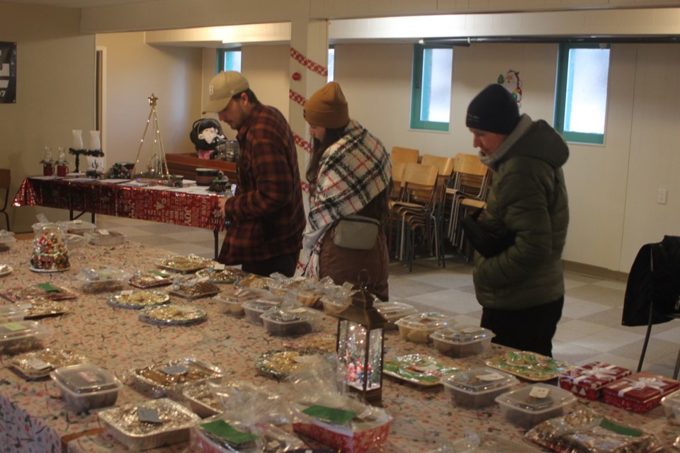 Loga Fabbro, Kenzie Fabbro, and April Fabbro peruse the wide selection of baked goodies for sale in the basement of St. Anne’s Roman Catholic Church in Venice. Chris McGarry photo. 