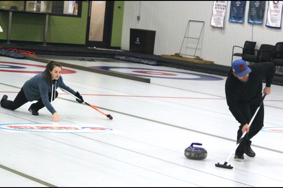 Josh Scott waits to sweep the rock, which is thrown by Becky Chwedoruk. Chris McGarry photo. 