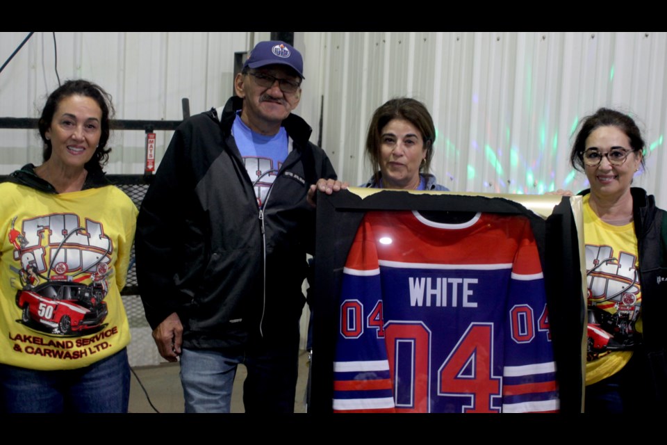 Annie, Soad and Tammy Tarrabain stand with Tom White, one of the original employees of what is now Tarrabain Dodge who has worked for the long-running Lac La Biche family business since its inception in 1974. White received a gift commemorating his years of service, and also helped to cut the celebratory cake. Chris McGarry photo. 