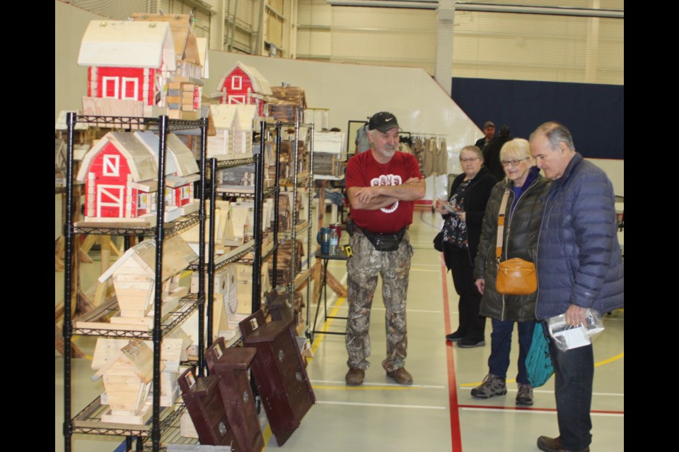 Bob Marcyniuk shows the birdhouses he made through his business, GO 4 IT ENTERPRISE, to Aurel and Marianne Langevin at the 13th annual Spring Sale, which took place at the Bold Centre on March 29. Marcyniuk, from St. Paul, makes these creations inside of a home-based workshop. Chris McGarry photo.