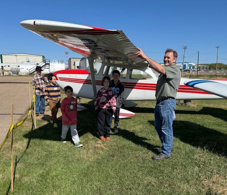 Boyd Harrison, a pilot from the Lac La Biche area, shows some of the youngsters who participated in the Discover Aviation event the wing of a plane. Submitted photo. 