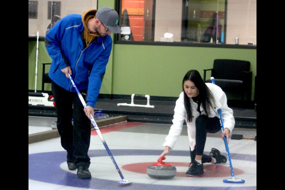 Sweet!  Sweet! On Friday, the Lac La Biche Curling Club held a couples-themed night, although singles were welcome as well. Brett Skakun and Mya Ullrich engage in a game of recreational curling at the event. Chris McGarry photo. 