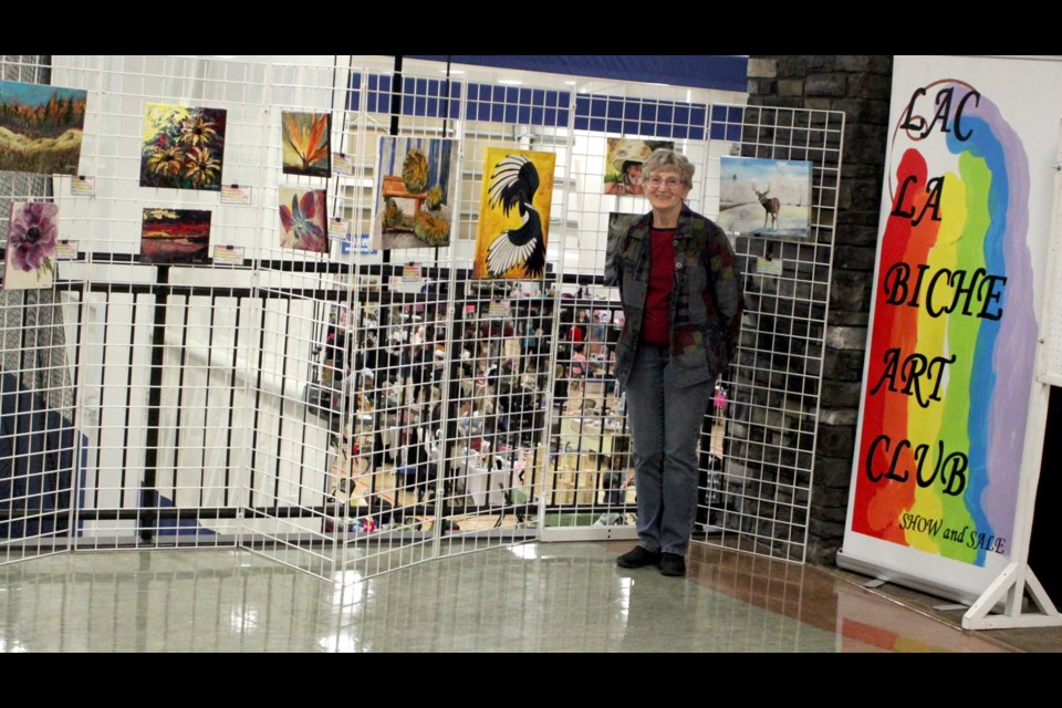 Clara McArthur, a member of the Lac La Biche Art Club, stands with some of the paintings done by members that were on display at the art show and sale. Chris McGarry photo.