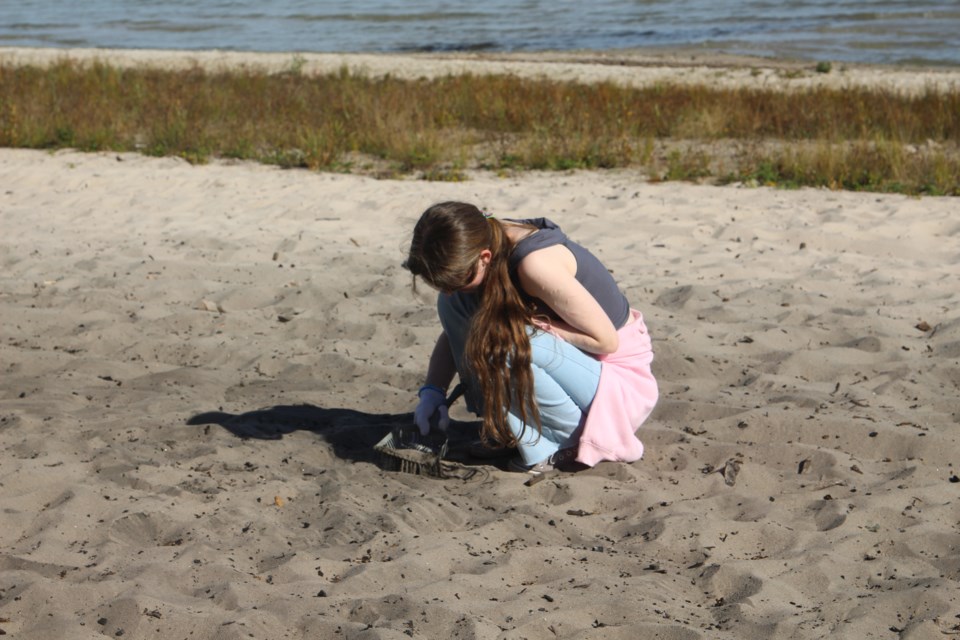 Some students were using litter scoops so siphon out debris that might be under the sand.