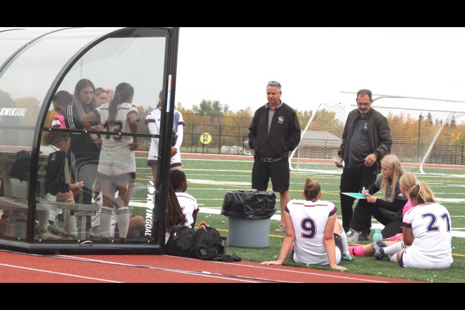 Al Bertschi and Al Robertson, who along with Mohamed Al-Hattab (not shown), replaced Portage College Voyageurs men's and women's soccer head coach Kika Mukininwa and Glenda Bouvier on Sept. 20, discusses game strategy with members of the women's squad during halftime at Sunday's match-up between the Voyageurs and the visiting Lakeland College Rustlers. In that double header, the men's squad were defeated 3-2 while the women dropped a 3-0 decision to the Rustlers. Chris McGarry photo. 