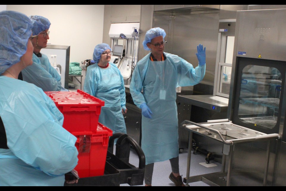 Cody Dingreville, Medical Device Reprocessing Lead with Alberta Health Services (AHS) North Zone, shows members of a tour group, including Lac La Biche County Ward 1 councillor Darlene Beniuk, the upgraded equipment inside of the medical device reprocessing area (MDRA) of the William J. Cadzow Healthcare Centre in Lac La Biche. Renovations of the MDRA were completed last August, after which new equipment was installed. Chris McGarry photo. 