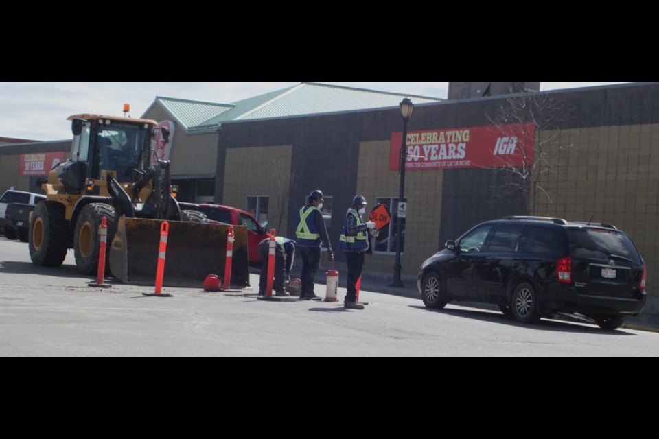 On Friday afternoon, construction crews were working on 101st St. connecting IGA’s temporary water line. One side of the street was closed, with flaggers directing traffic through the area. Chris McGarry photo. 