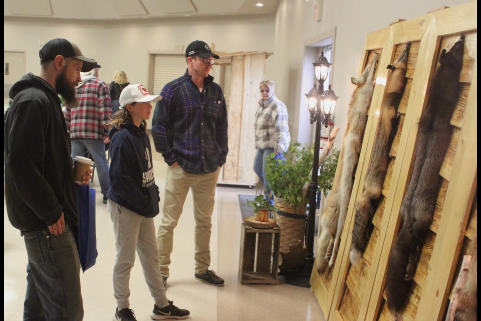 Dan McLean, Olyve Abercrombie and Malcolm Abercrombie check out the furs on display inside of the Plamondon Festival Centre during the 50th Rendezvous and Outdoorsman event, which took place from July 4-5. The event, which was put on by the Lac La Biche Trappers Local 1120 and the Alberta Trappers Association, brought trappers and their families to Plamondon from different areas of Alberta. Chris McGarry photo. 