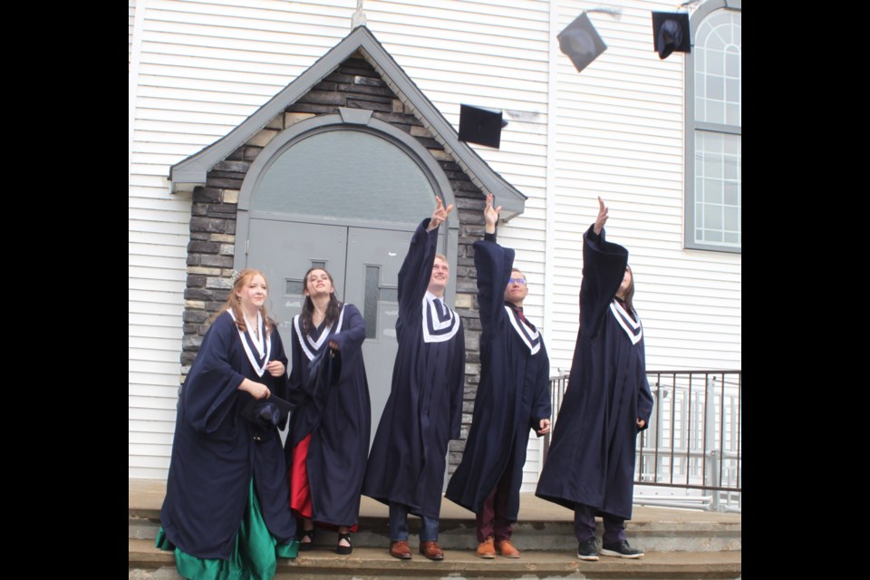 Ecole Beausejour 2025 graduates Danique Plamondon, Laurie Thibault, Finley Doody, Tyson Chamzuk, and Noah Malo participate in the customary cap-tossing event during the graduation ceremony, which took place on June 14. Chris McGarry photo. 