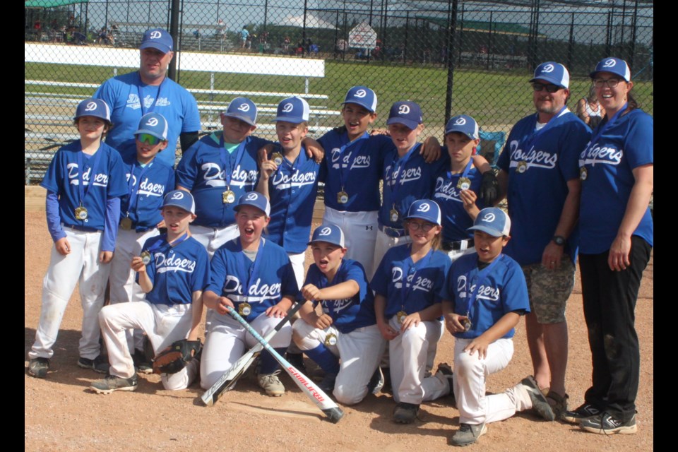 The members of the Lac La Biche Dodgers 11U team pose with their gold medals after winning the final match against the St. Paul Storm that wrapped up the 11U baseball and U11 softball tournaments which took place at the Bold Centre ball diamonds over the June 21 weekend. 
In photo, back row, left to right; Chase Hodgins, Jaxen Sturges, Odin Twigge, Cole Tredger, Amir Eludin, Easton Downes, and Sutton Kumpula.
Front row, left to right; Griffin Davies, Jessilyn Richard, Jase Bobocel, Finley Clark, and Logan Thompson. 
Coaches are Dustin Downes, Aaron Hodgins, and Joanna Bobocel. Chris McGarry photo.
