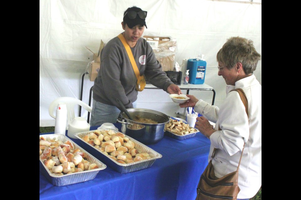 Tessa Kumpula hands some traditional Filipino cuisine to Donna Fabbro. Chris McGarry photo. 