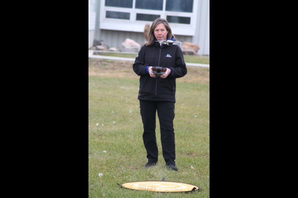 Wanda Plamondon steadies a drone over a landing pad that had been set up on the soccer field next to Portage College. Chris McGarry photo. 