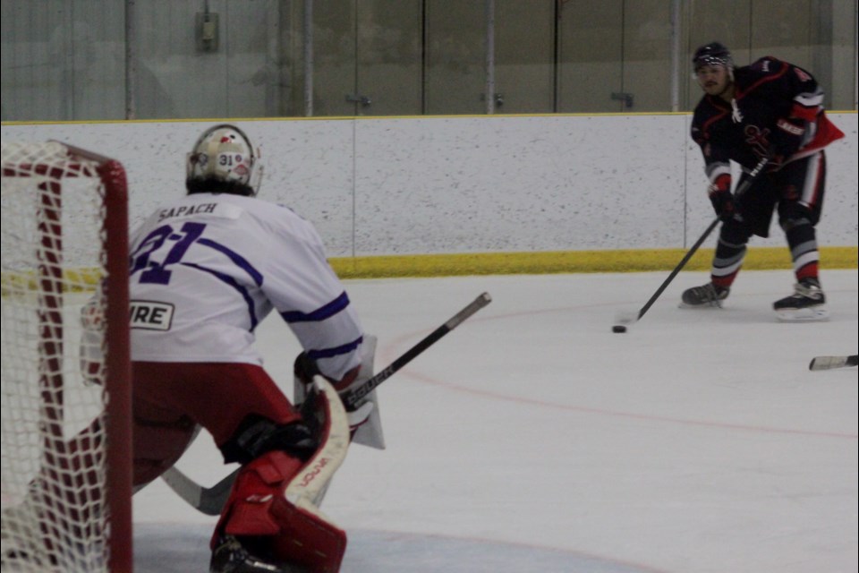 Edson Eagles goaltender Carter Sapach gets ready as Lac La Biche Lakers defenseman Torin Tailfeathers advances towards his net with the puck. Chris McGarry photo.