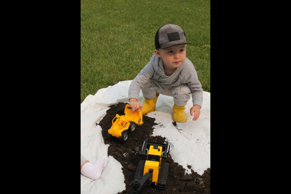 Eli Tkachuk plays with construction toys in one of the sandpits set up on in McArthur Park last week for the  FCSS Messy Play Day.
 Organizers say there's no better way for children to learn socialization, language, and motor skills than by engaging in some good, old-fashioned play in the dirt. The weekly event is a component of the FCSS Young Family Connections program. It is designed for youngsters aged up to six, giving them an opportunity to learn sensory exploration by participating in such messy activities as painting sidewalks and walking paths, experimenting with foam and other substances, or simply playing around in the mud. Messy Play Day takes place at McArthur Park every Thursday from 10:30 – 11:30. 