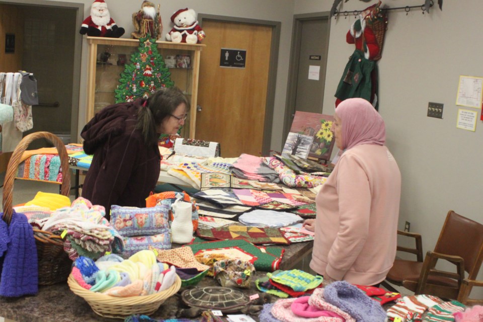 Marian Ewaskiw browses the various items for sale at a table ran by Fatima Taha during the Christmas craft sale, which took place Saturday at the Lac La Biche Heritage Society. Chris McGarry photo.