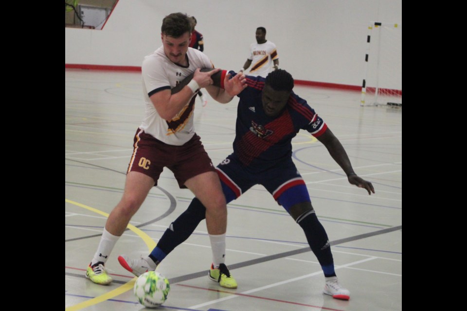 The 2024 Alberta Colleges Athletic Conference (ACAC) Futsal Championships got underway Friday evening at the Bold Centre. The Portage College Voyageurs faced off against the Olds College, winning the game 6-2. Fiston Kiese of the Voyageurs struggles with Broncos player Pedro Noschang. Chris McGarry photo. 