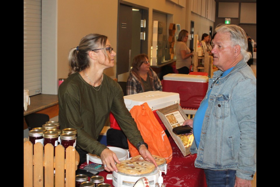Glenda Summers, who is a familiar face at the Lac La Biche Farmers Market throughout season, talks with Michael Langlois. They were at the first farmers market of the 2025 season, which was held at the Lakeland Agricom on April 11. Chris McGarry photo. 
