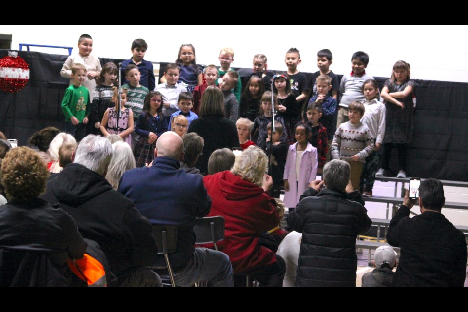 Members of the audience watch and take photos as Grade 1 students take to the stage during the concert. Chris McGarry photo. 