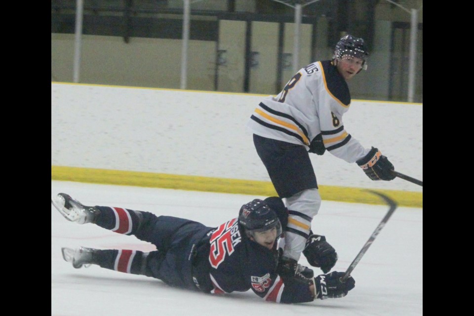 Portage College Voyageurs defenseman Sasha Jirousek slides into Brandon Wallis of the CUE Thunder during Friday’s game at the Bold Centre. The Voyageurs won the game 6-2. — Chris McGarry photo.