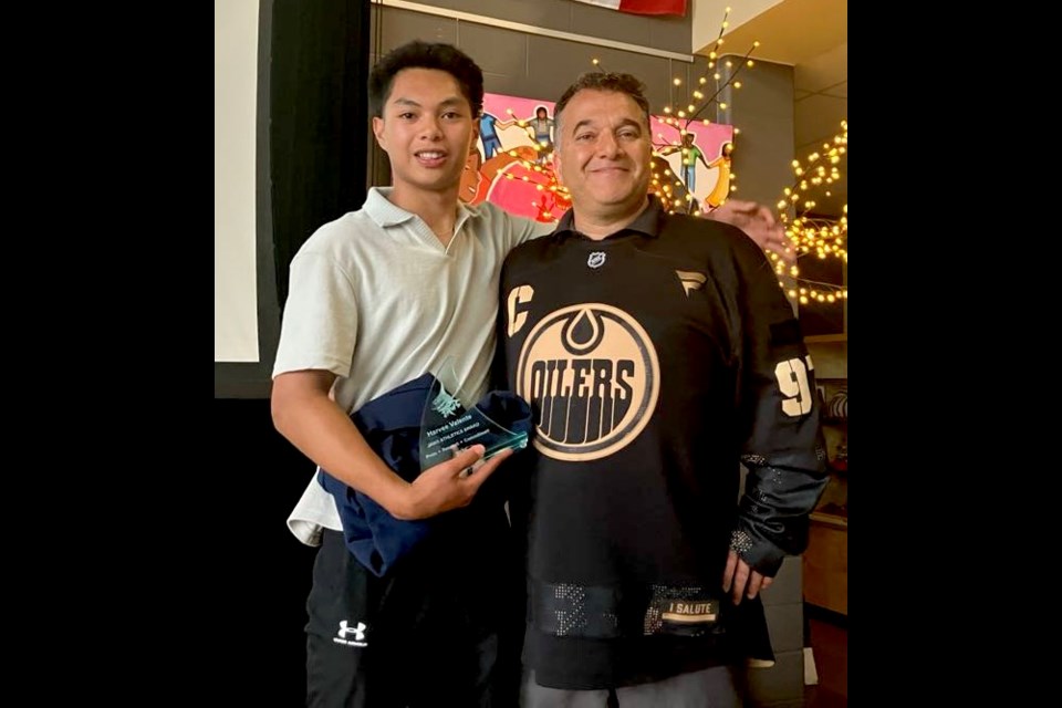 Harvee Valente, a graduate of the JA Williams (JAWS) Class of 2025, stands with principal Sam Abougouche after receiving the JAWS Iron Shark award at the JAWS annual athletic banquet, which took place at the school on June 12. Chris McGarry photo. 