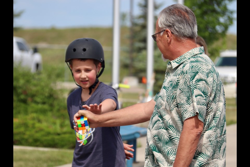 Leland Warburton shows Town of Bonnyville Coun. Brian McEvoy how to hand-off the Rubik’s cube during the practice run.