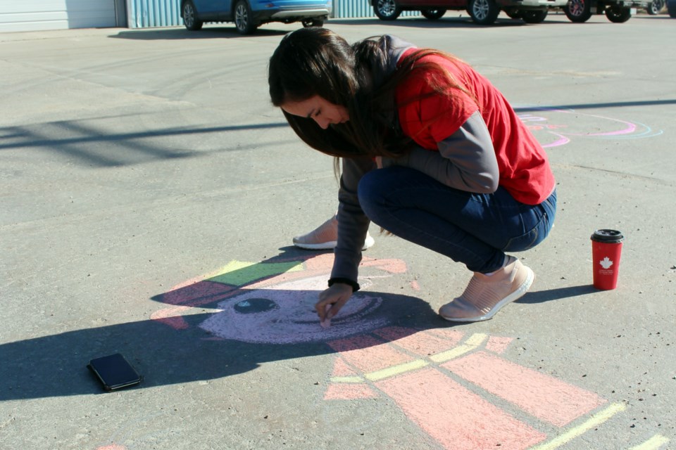 Katlyn Strzepek draws a firefighter in the driveway of the Bonnyville Regional Fire Authority Station 5 on Tuesday, May 5. Photo by Robynne Henry. 