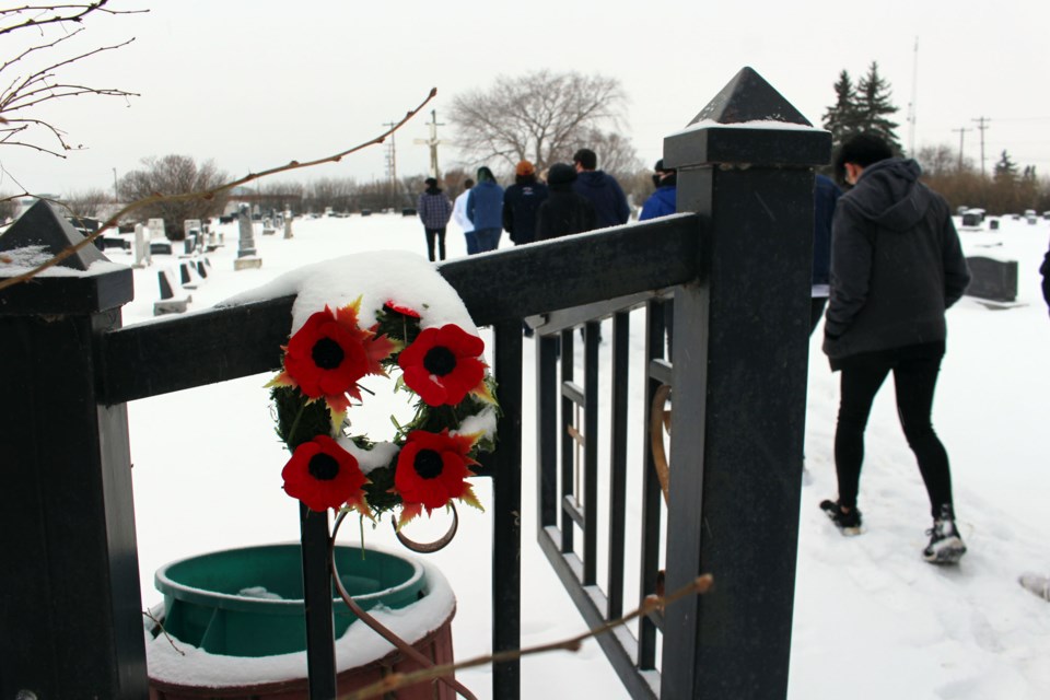 Students from Notre Dame High School (NDHS) stopped at local cemeteries to lay poppies down on gravesites of former military members as part of the No Stone Left Alone initiative. Photo by Robynne Henry. 