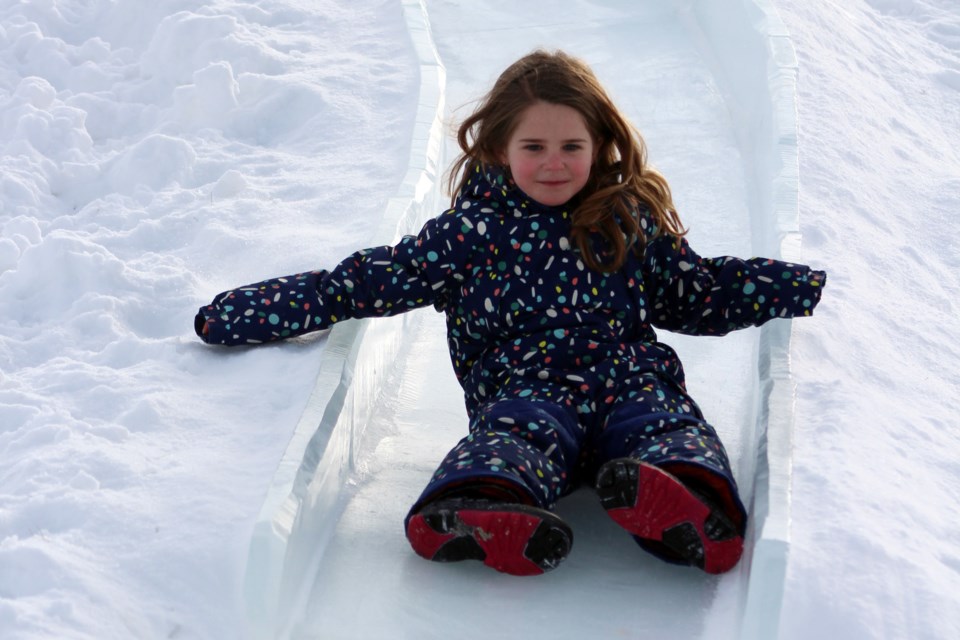 Six-year-old Edith Vardy couldn’t wait to go down one of the ice slides during Cold Lake's Snow Fever over the family day weekend. Photo by Robynne Henry. 