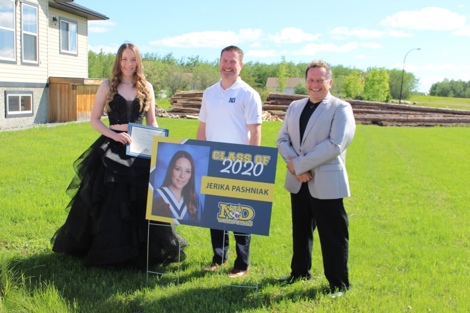 Grad Jericka Pashniak poses for a photo with Notre Dame High School principal Vince Spila and vice principal Jeff Cey on Thursday, June 18. Photo by Robynne Henry.