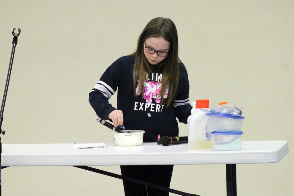 Lainey McMillan, junior Lakeland Long Riders member, shows the audience how to make slime. Photo by Robynne Henry. 