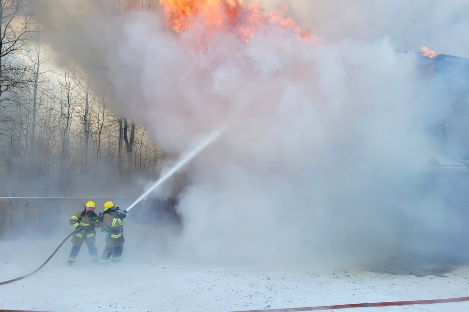 Firefighters battle a fire in the Lac Santé area on Tuesday, in extremely cold temperatures. Photo supplied.