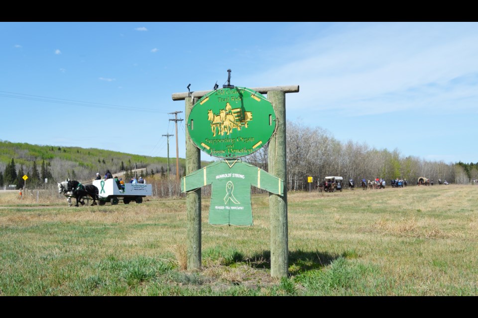 The 14th Annual 2nd Chance Trail Ride approaches the crossing of Highway 646 as they pass a carved sign supporting organ and tissue donation and a second sign remembering the victims of the Humboldt bus crash, an event which led to many individuals across Canada signing their donation cards.