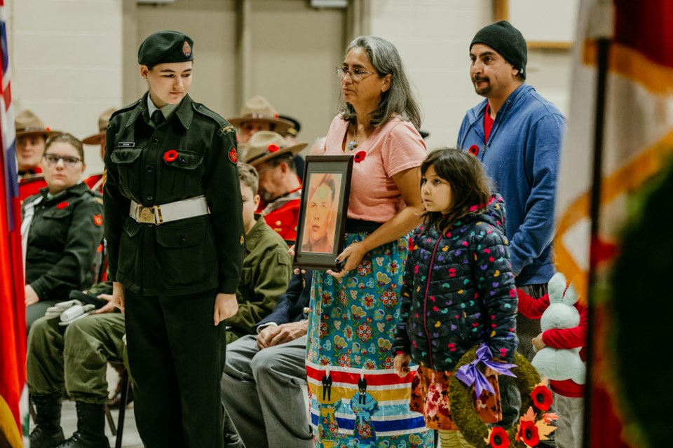 Shannon Houle carries a photo of veteran Joseph Houle during the Nov. 11 Remembrance Day ceremony in St. Paul.