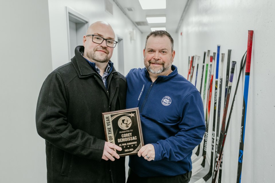 Coach Corey deMoissac hold his Coach of the Year plaque alongside Canadiens' President Derrik Germain.