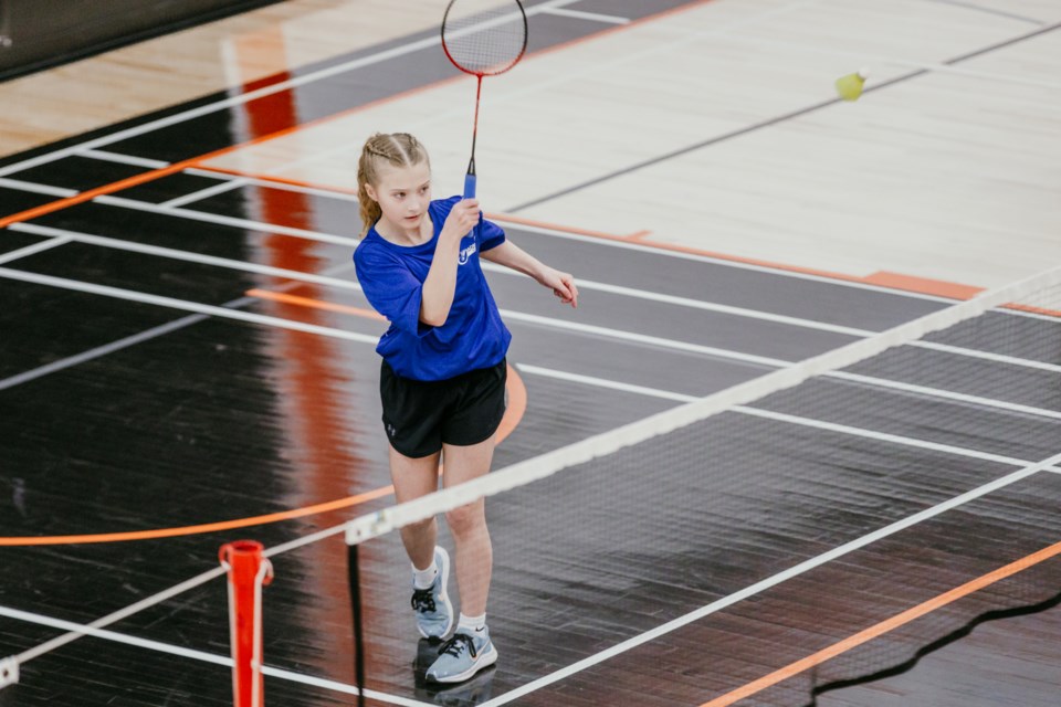 A Racette School student serves the shuttle during a badminton tournament on April 13.