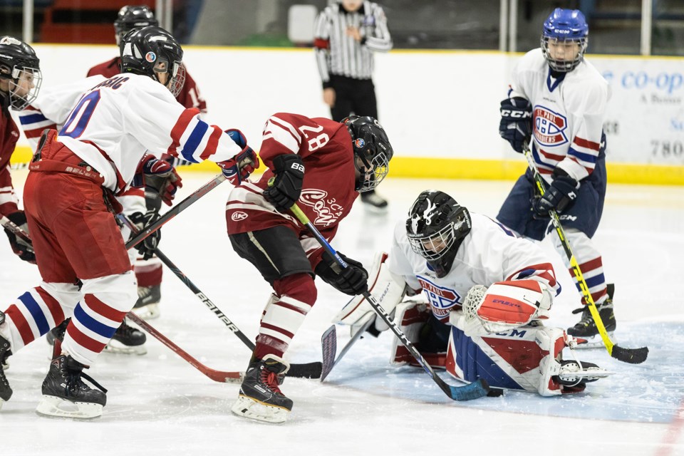 St. Paul Canadiens goalie Tate Wilson stops a puck during the second period of the final game of Sunday’s U13-1 tournament at the Clancy Richard Arena. The St. Paul team won the game against the central Alberta 3C’s by a score of 9-4. Also pictured is Cruz deMoissac (left) coming in to help get the puck away from the net. / Janice Huser photo