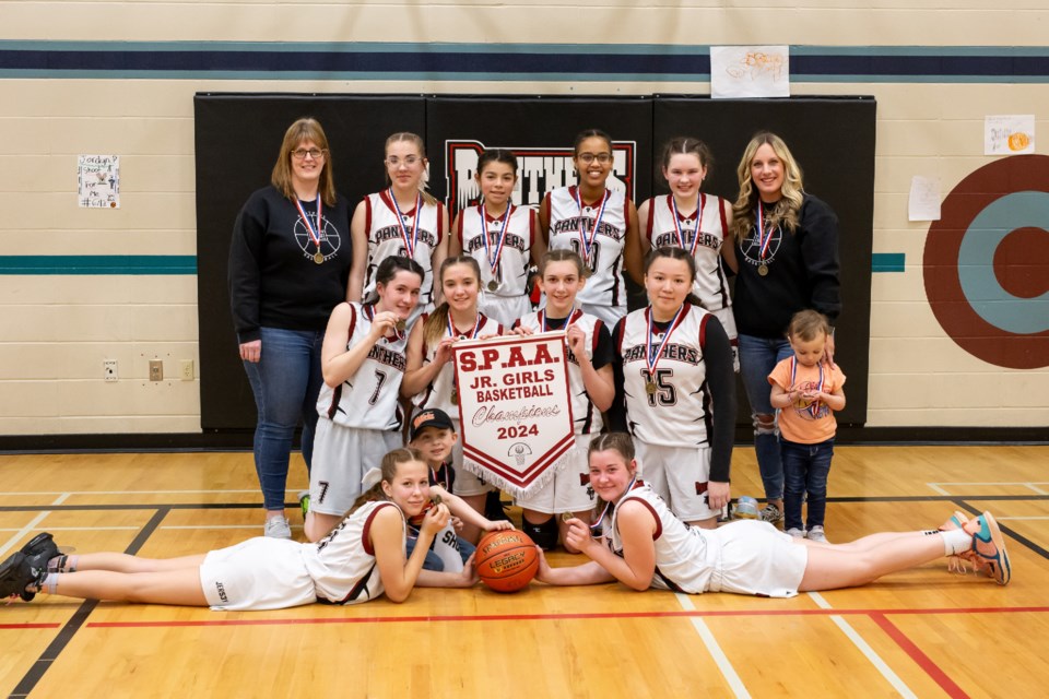 The Glen Avon girls' team poses with the SPAA junior basketball banner.