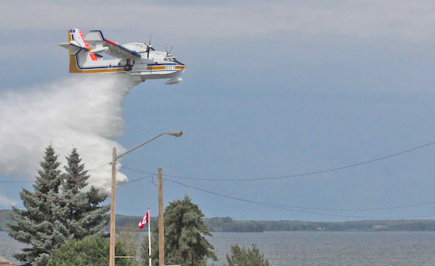 An air tanker drops a water load over the shoreline of Lac La Biche lake in this file photo from a recent demonstration event. Despite an early start to the fire season, the tankers won't have access to water until the area lakes thaw.
