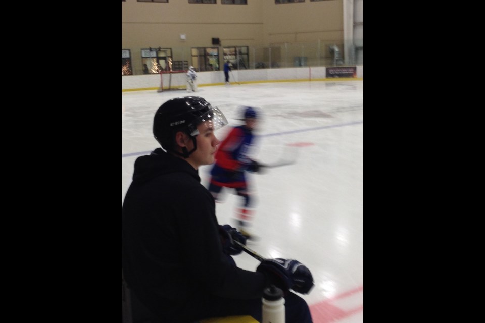Alex Bell looks out over a practice of Lac La Biche minor hockey team. As a junior B goalie, Bell would spend many hours a week volunteering at minor hockey practices.   Image Rob McKinley
