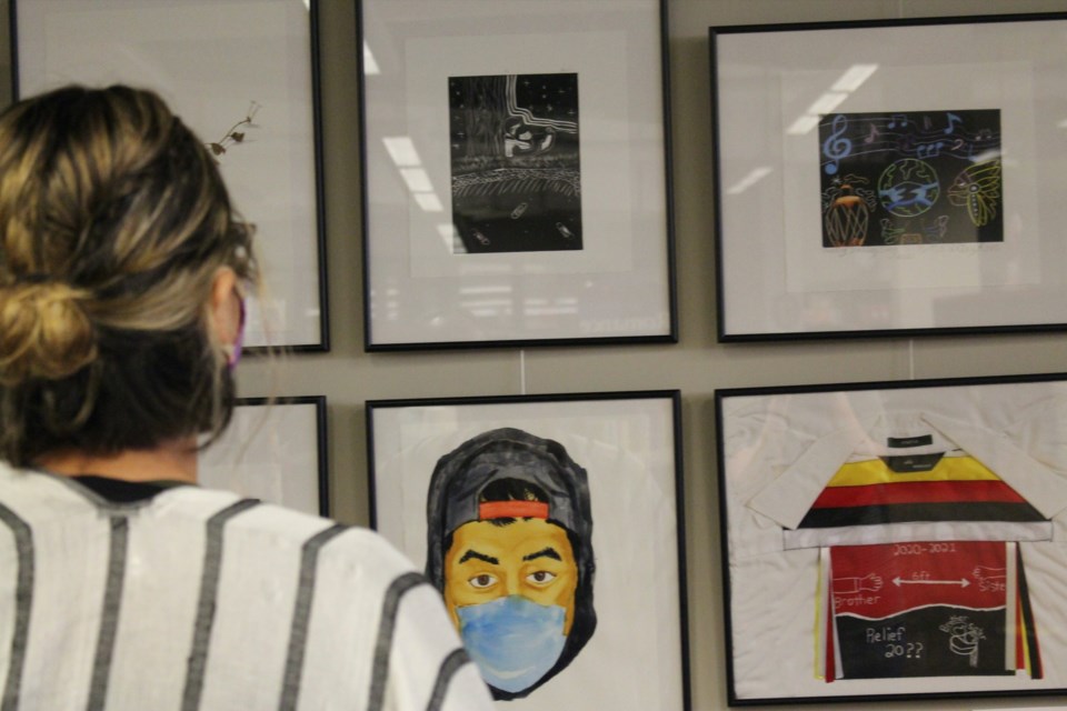 A library visitor looks at some of the pieces on display in the new Time Stamps: The Art of Exhibition at the Stuart MacPherson Public Library. The local display features international content relating to the effects of the coronavirus pandemic.