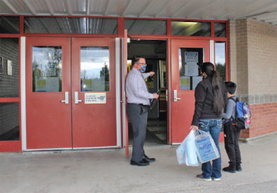 Aurora Middle School principal Conal Donovan welcomes students and families back to school in this file photo from the start of September. School officials announced Tuesday night that the school is tied to an active case of COVID 19.       File Rob McKinley