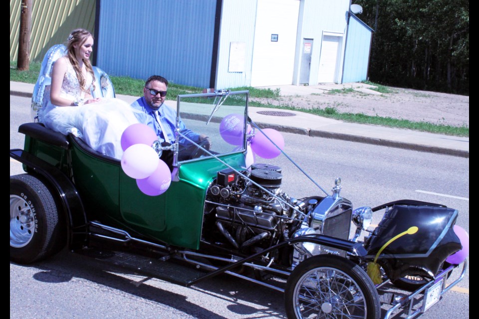 With her dad Kevin at the wheel of a family hot-rod, JAWS grad Avery Kuraitis rides in style for the grad parade. The JAWS and Ecole Plamondon graduation ceremonies were both held last Saturday.