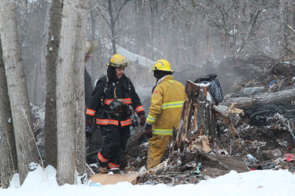 Fire crews survey the charred pile of debris looking for hot spots after Thursday morning's fire call at the Bonesville subdivision.