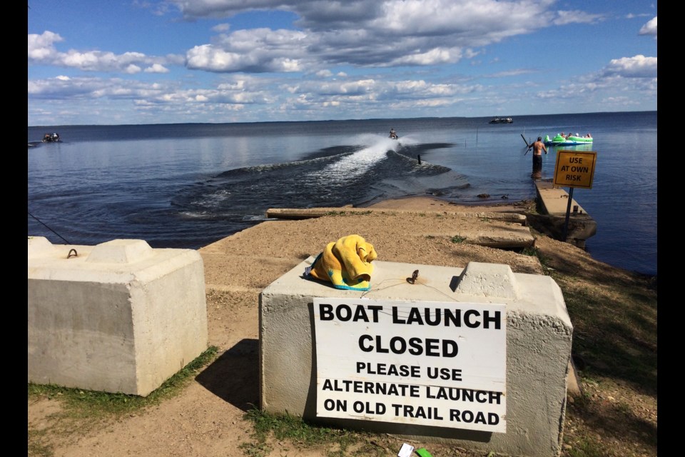 A jet ski rider accelerates away from the shoreline near the White Sands boat launch area. The old launch site may not be removed this year.