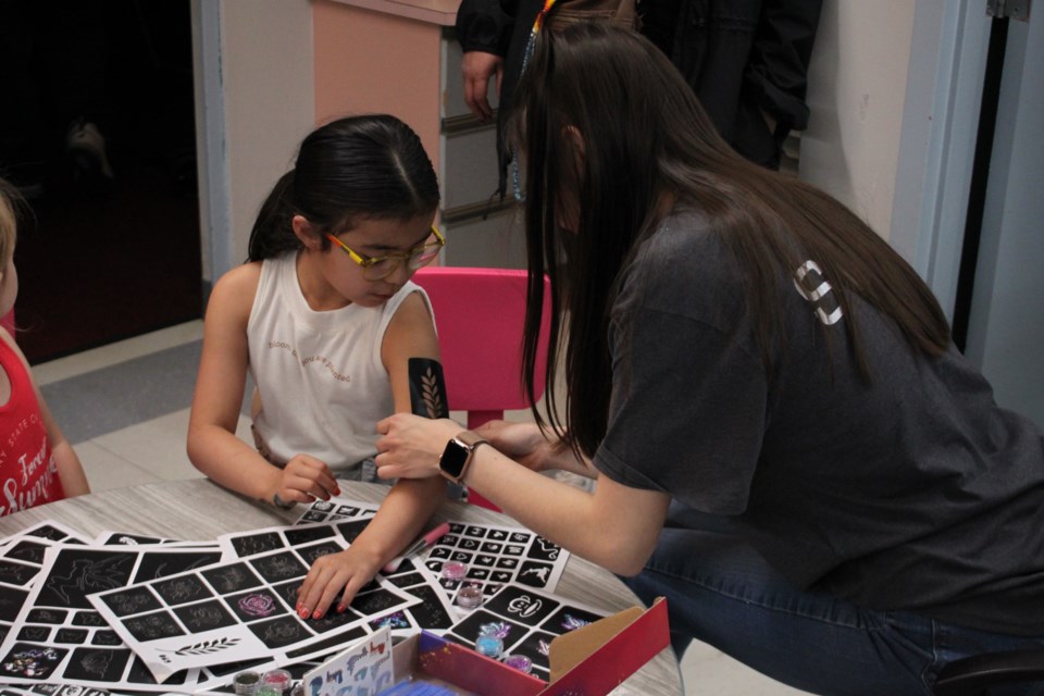 Brielle bull getting a glitter tattoo at one of the many kids activity stations.