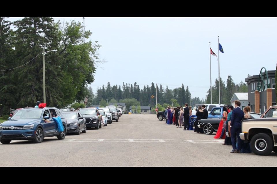 Glendon graduates stood outside the school as a grad parade of cars drove by to congratulate them - a tradition born from the days of social distancing.