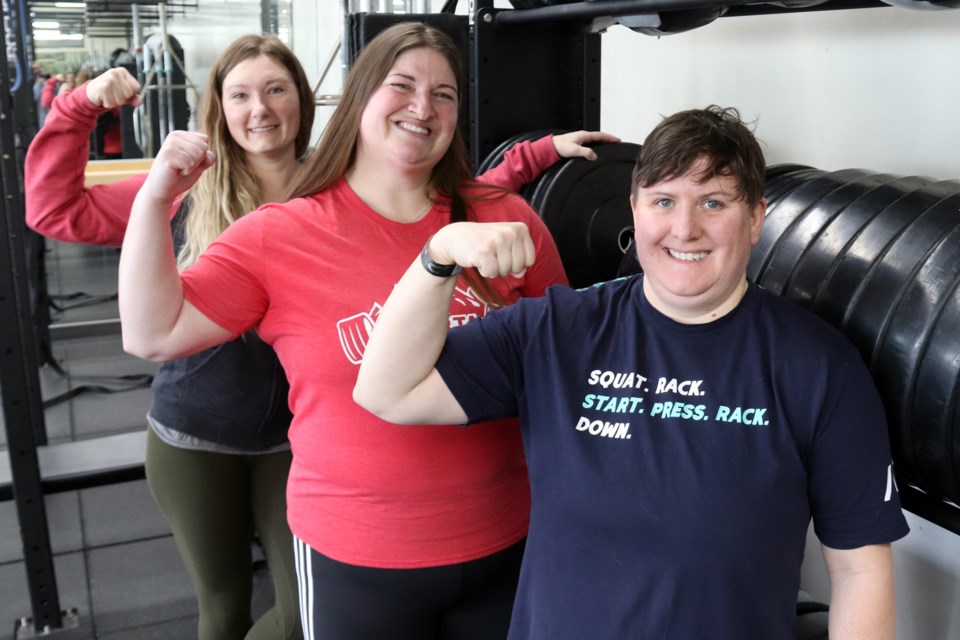 Local powerlifters Janine Hebert (centre) and Carole Vachon (right) pose for a photo with their coach Jessica Brennan (left) after sharing their experience at CPU Nationals. Photo by Meagan MacEachern. 